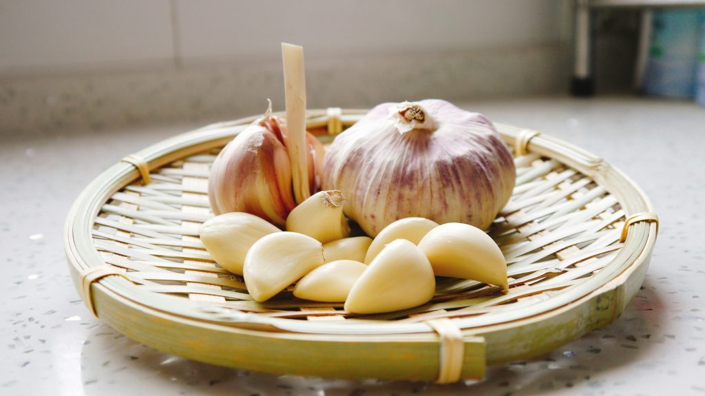 A basket of fresh garlic cloves, an immune-boosting food used in nutritional strategies to fight infections naturally