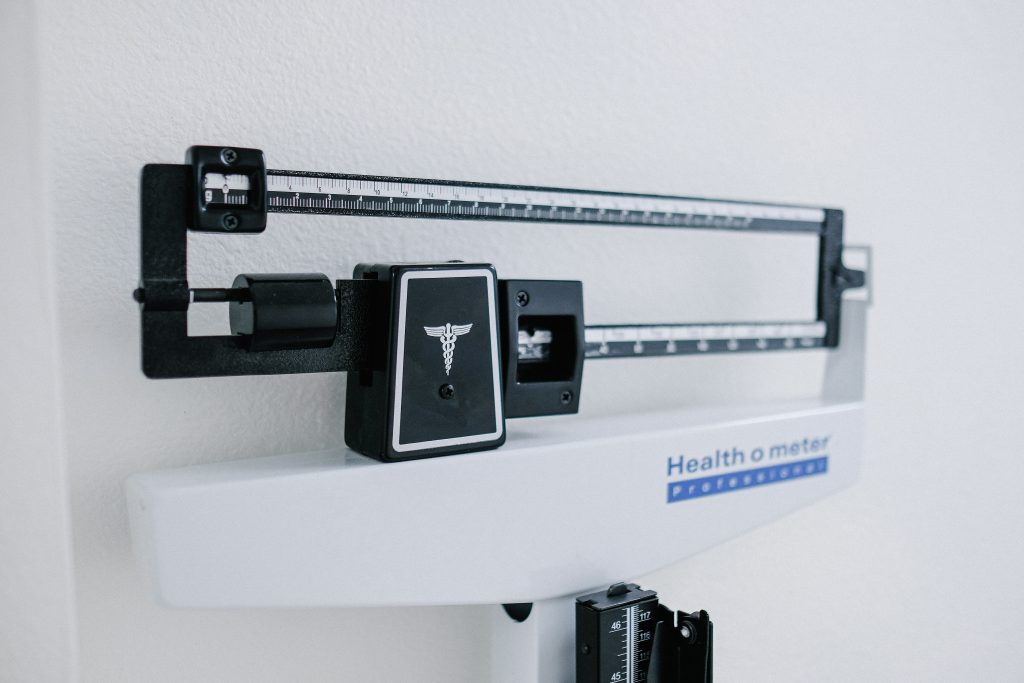 A professional medical beam scale in a clinic setting, representing the metabolic tracking and weight loss progress monitored by a nutritionist or dietician in Las Vegas.